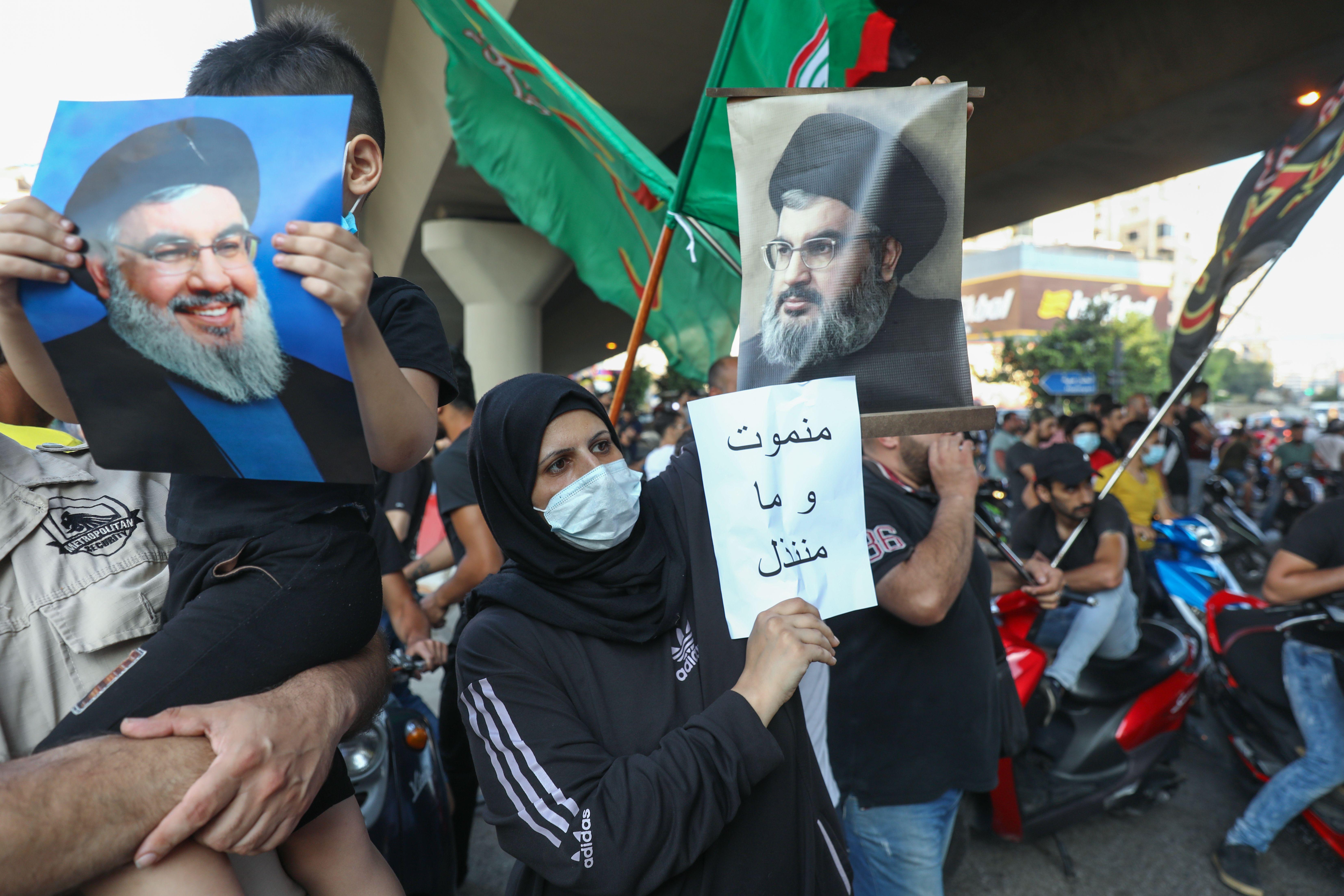 متظاهرون يرفعون صور حسن نصرالله وأعلام حركة أمل