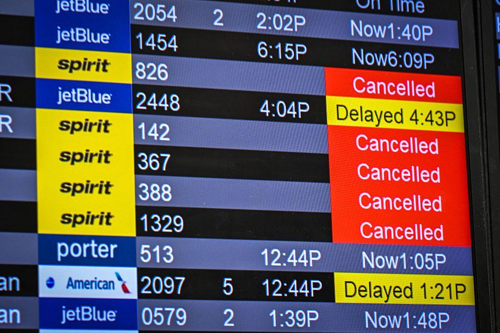 Un tablero de vuelos de un aeropuerto muestra las cancelaciones de Spirit Airlines