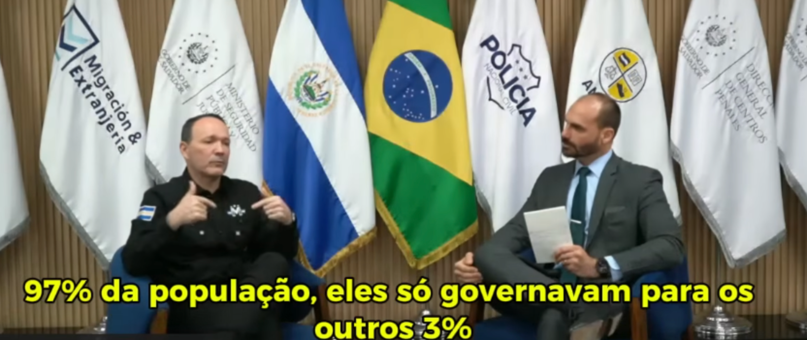 O ministro da segurança pública de El Salvador, Gustavo Villatoro, e o deputado federal Eduardo Bolsonaro, em entrevista publicada no Youtube do deputado. Na imagem aparecem bandeiras dos dos países ao fundo.