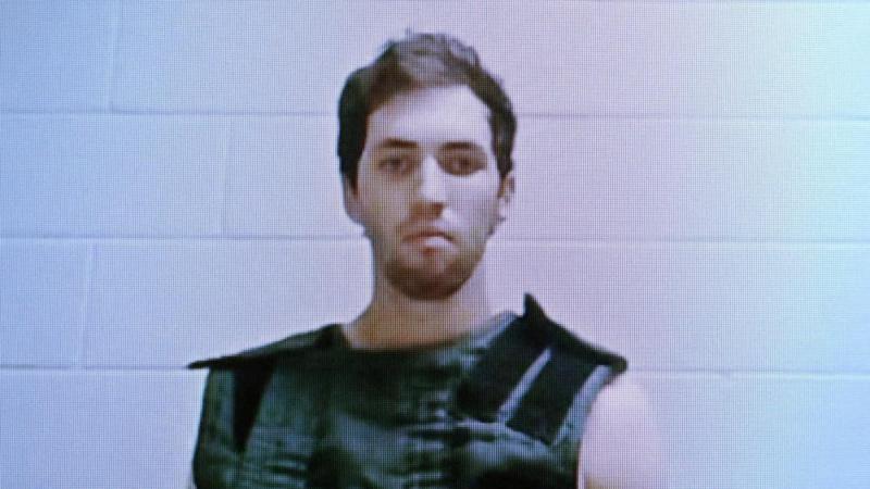 Foto policial de Tyler Robinson, acusado del asesinato del activista conservador Charlie Kirk, mirando serio a cámara, con un chaleco protector