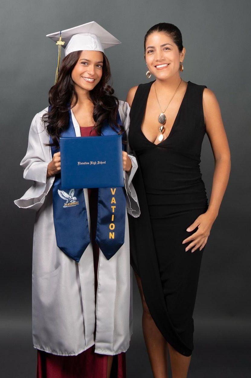 Giulianna Carriel y su tía Gia Calero. Una chica con traje de graduación de secundaria junto a una mujer con vestido negro y el pelo tomado.