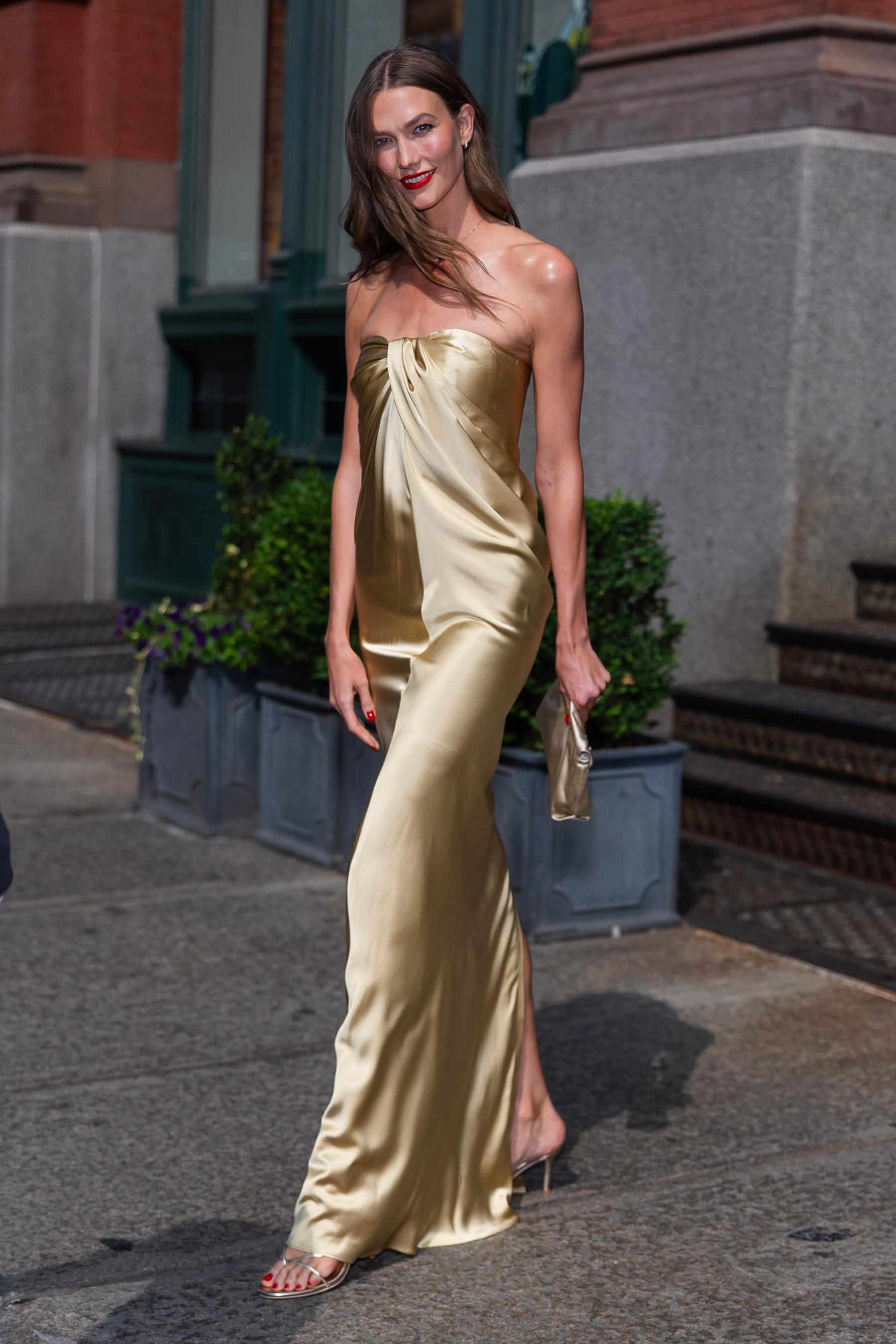 Karlie Kloss em um vestido longo dourado sem al&ccedil;as