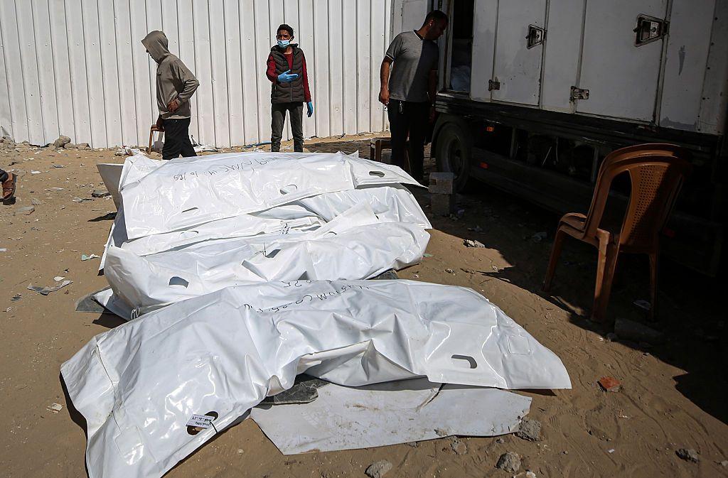 Los trabajadores de la morgue descargan los cuerpos de palestinos que están bajo custodia israelí después de ser transportados en vehículos de la Media Luna Roja y camiones refrigerados al hospital Nasser en Khan Yunis, Franja de Gaza, el 15 de octubre de 2025.