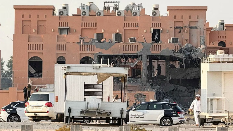 مبنى تعرض لأضرار بعد أن استهدفته إسرائيل في العاصمة القطرية الدوحة، أمامه سيارات للشرطة القطرية.
