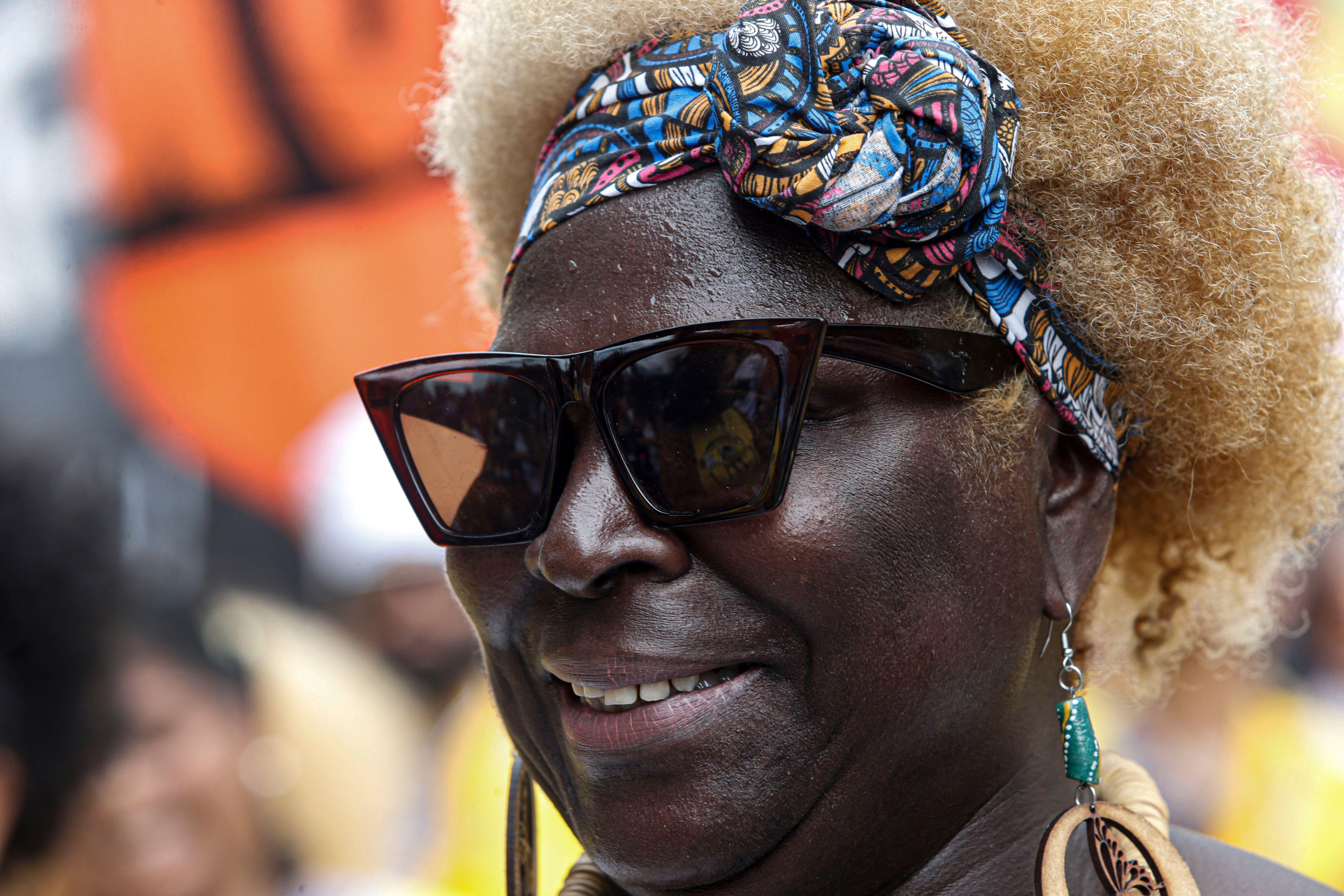 Mulher negra usando óculos escuros e uma faixa no cabelo crespo