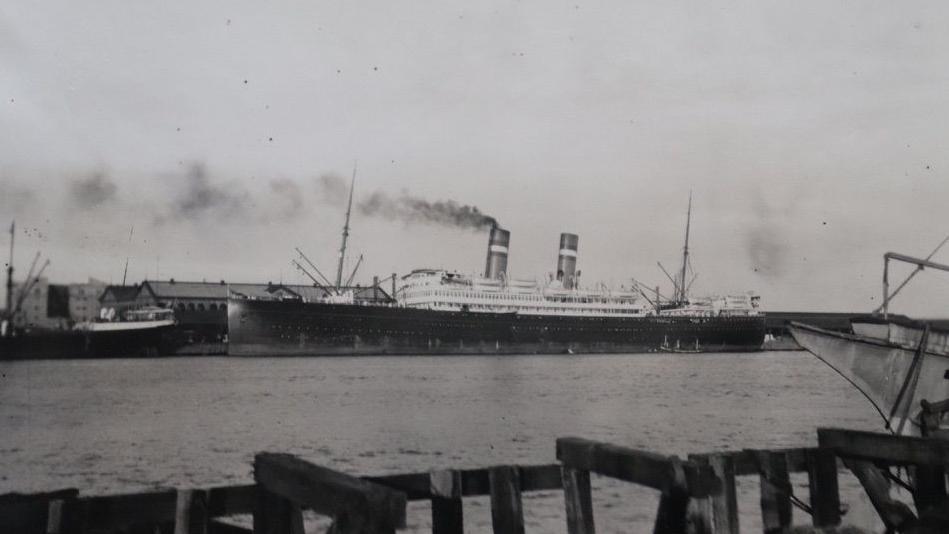 Un buque de dos chimeneas, anclado en un puerto