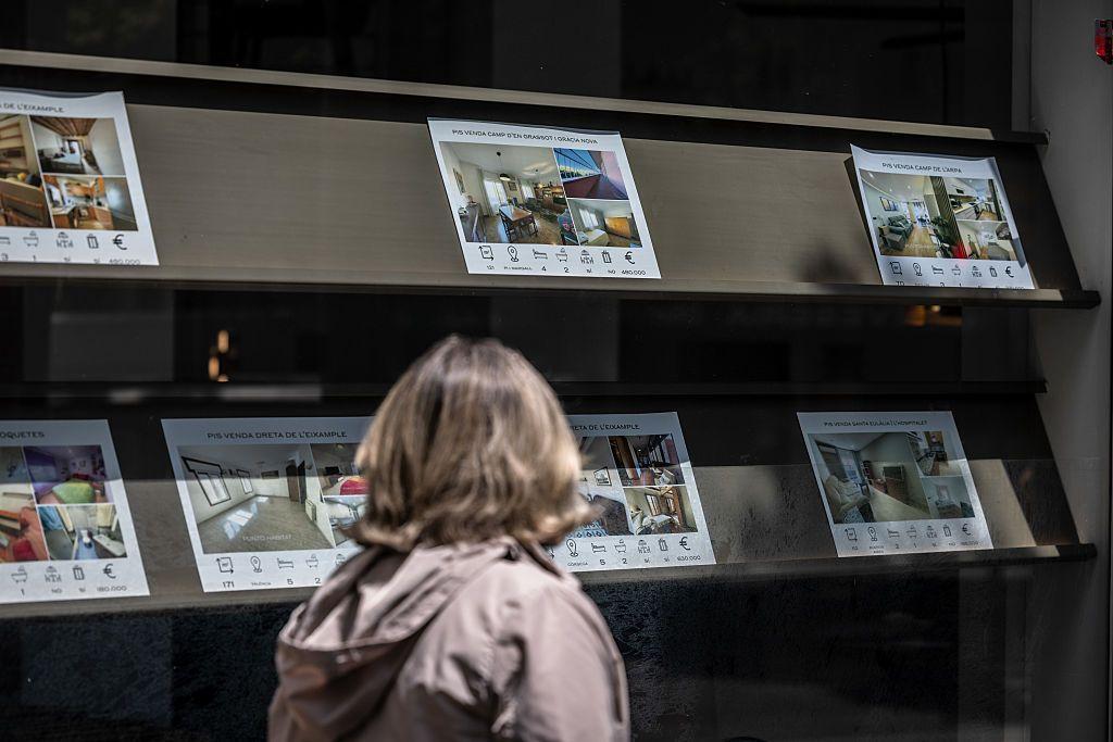 Una persona observa anunciós de viviendas dispobibles en el escaparate de una agencia inmobiliaria en Barcelona. 