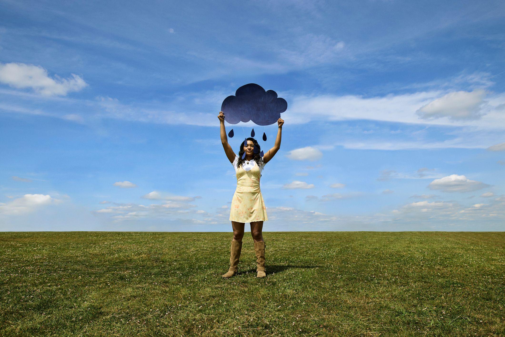 Žena na proplanku drži oblačić u rukama