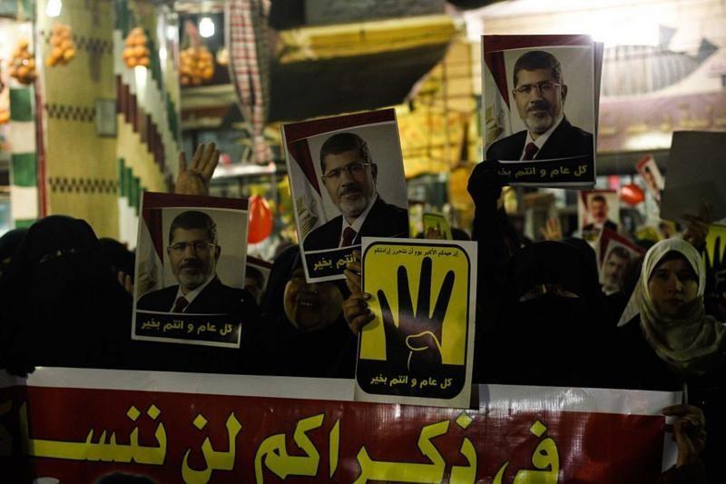 رُفعت لافتات تحمل صور محمد مرسي وشعار رابعة في مظاهرة في غزة عام 2016.