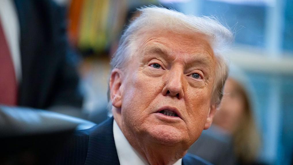 El presidente de Estados Unidos, Donald Trump, en primer plano una comparecencia en el Despacho Oval. 