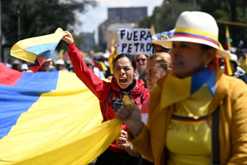 Personas en una manifestación contra el presidente de Colombia con banderas del país y un cartel que dice "fuera Petro" en Bogotá en marzo de 2024. 