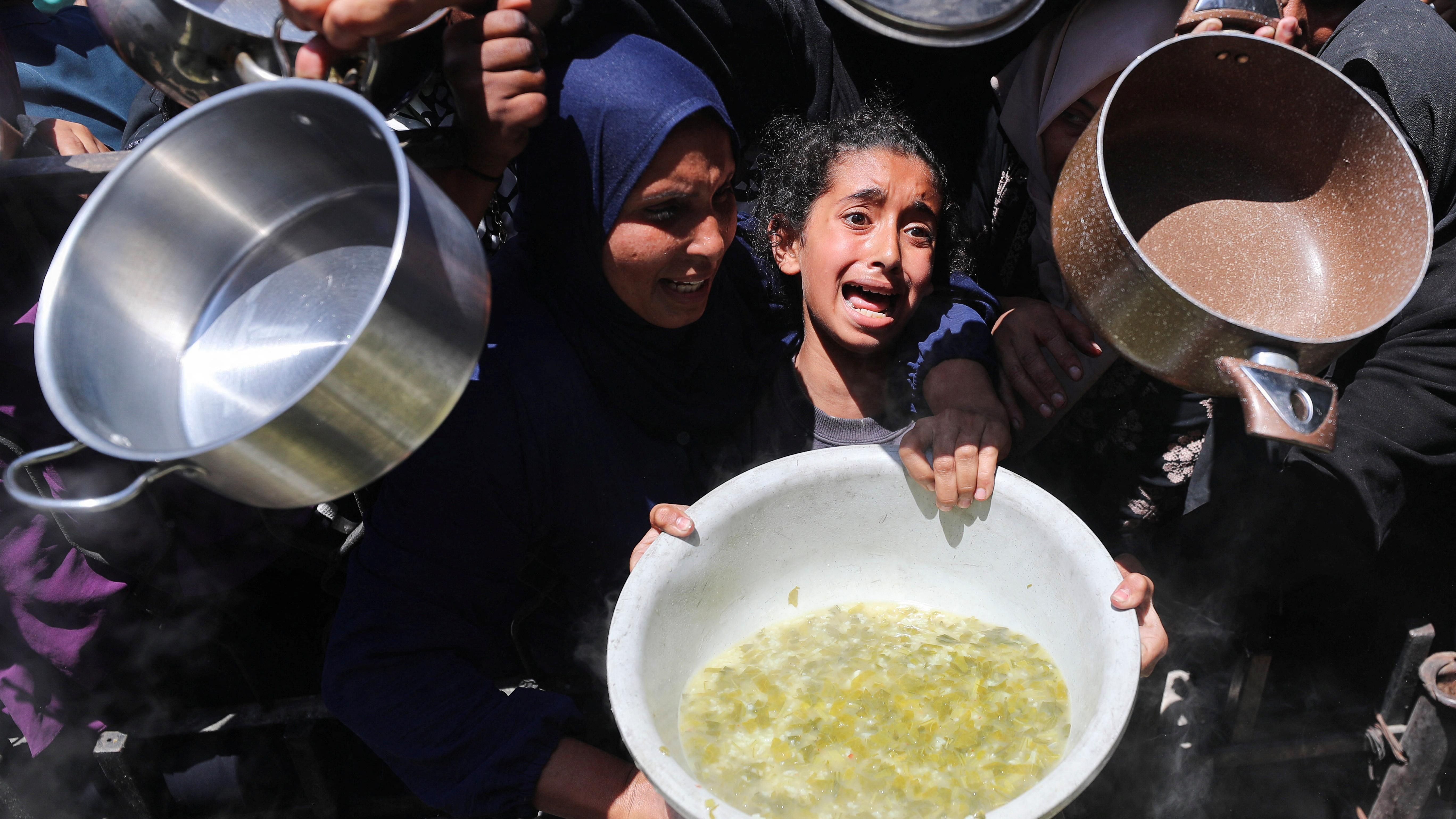 "أخشى أن أخرج بكيس للبحث عن الطعام، فأعود محملاً فيه كجثة"، روايات من غزيين حول معاناتهم مع الجوع 1 فتاة تبكي، بينما ينتظر فلسطينيون الحصول على طعام مطبوخ في مطبخ خيري، في بيت لاهيا، شمال قطاع غزة