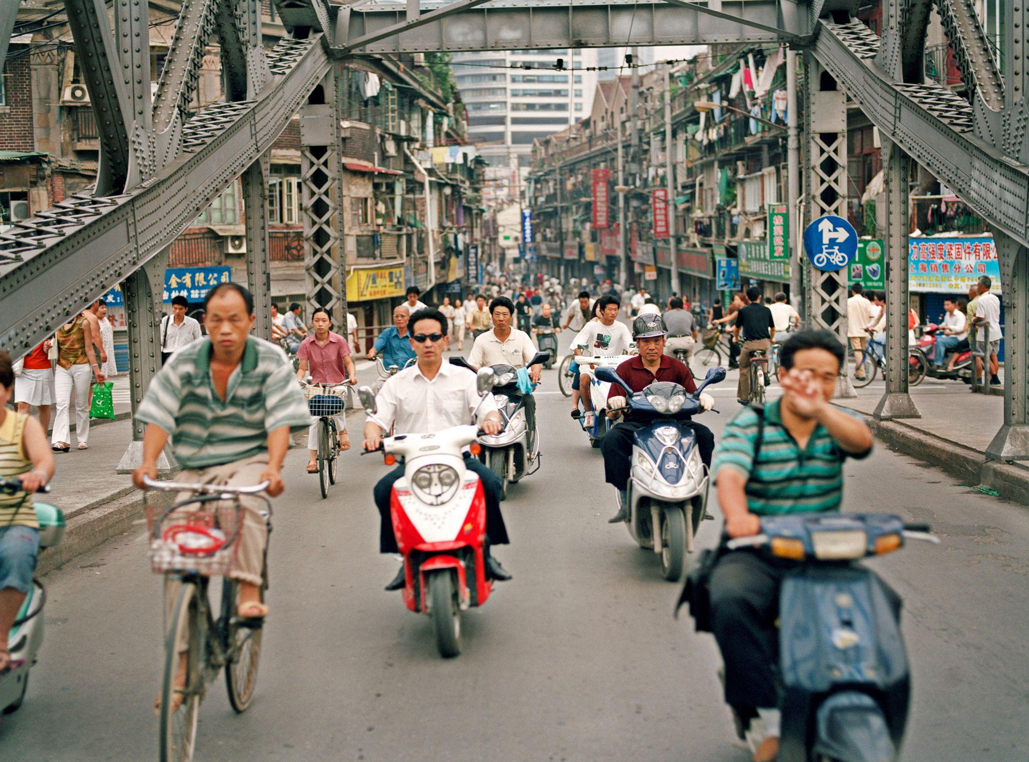 Pessoas andando de scooter em Xangai