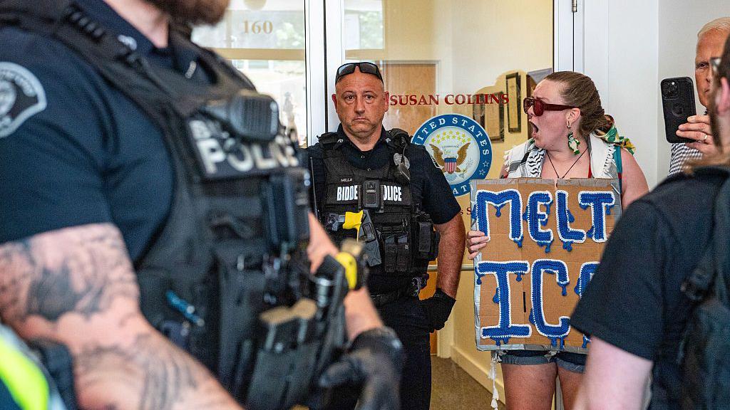 Manifestantes frente a la oficina de Susan Collins, junto a la policía.