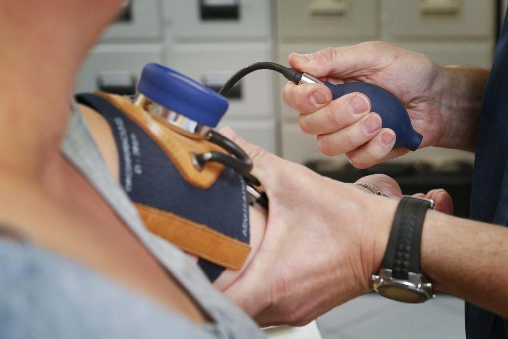 Un enfermero le toma la presión arterial a una paciente.