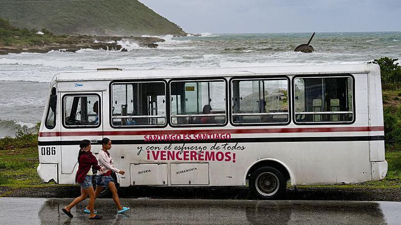 Personas en Santiago junto a un bus