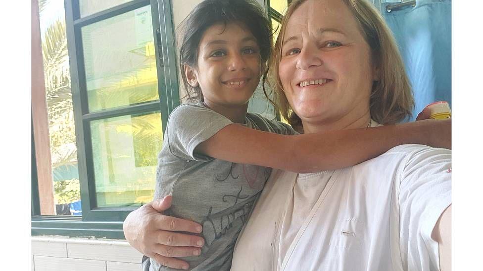 Katrin sonríe a la cámara con una niña en brazos en el hospital Nasser en Gaza