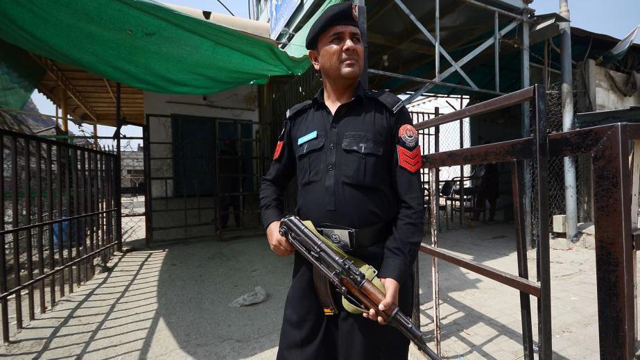 Un soldado de las fuerzas de seguridad de Pakistán de uniforme oscuro sostiene un rifle de asalto AK74 en un punto de control fronterizo