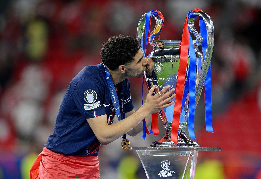 أشرف حكيمي لاعب باريس سان جيرمان يقبل كأس دوري أبطال أوروبا