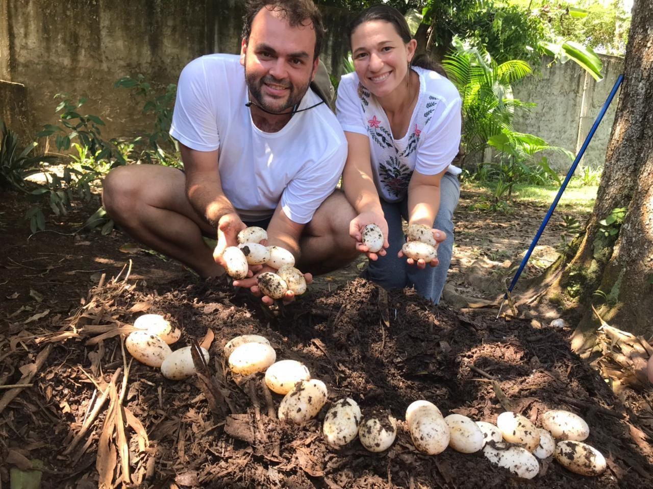 Breno e Milena Almeida segurando v&aacute;rios ovos nas m&atilde;os.
