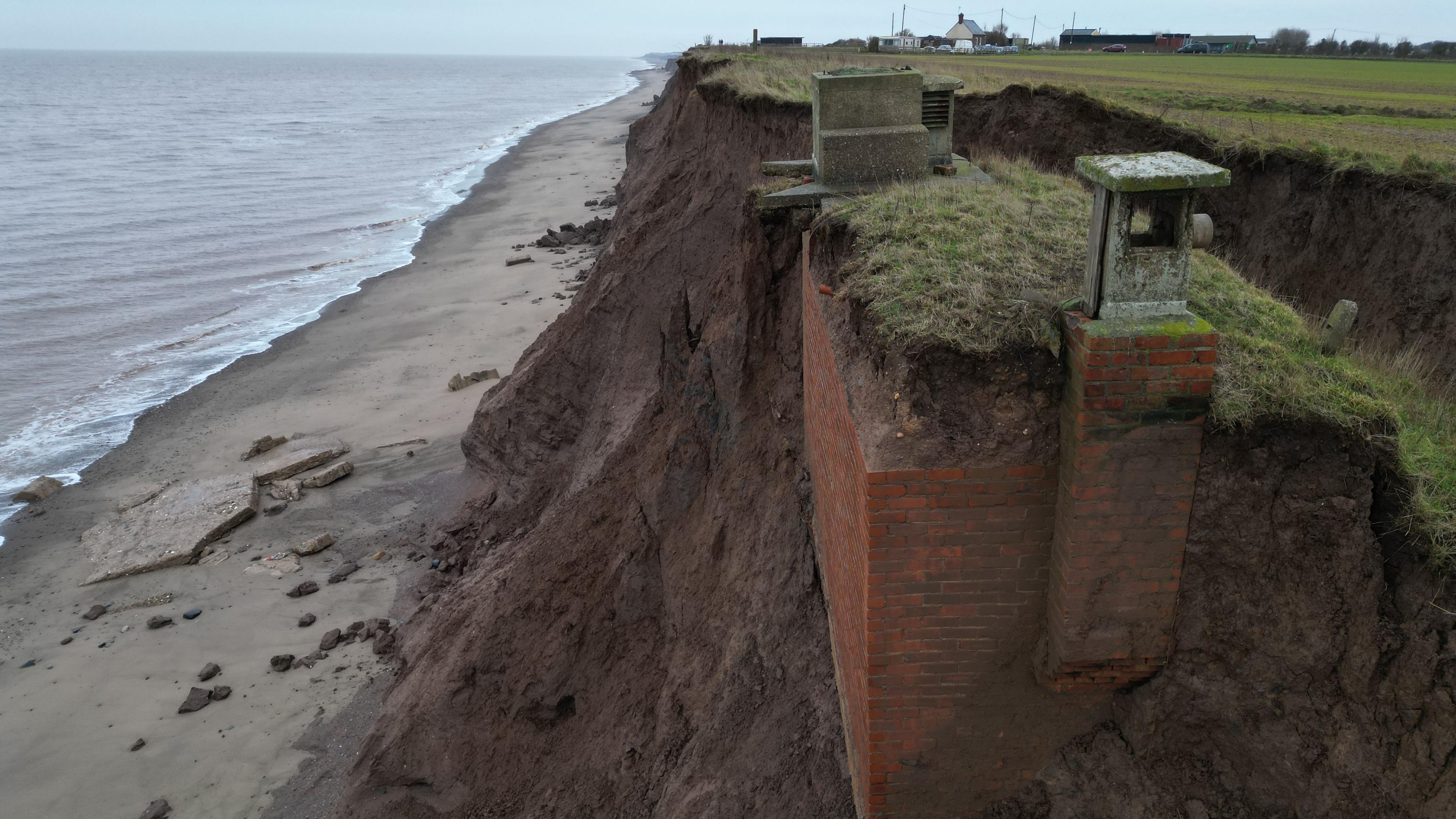 El búnker, una construcción de ladrillos, parcialmente expuesto, en el acantilado sobre el mar en que se construyó. 
