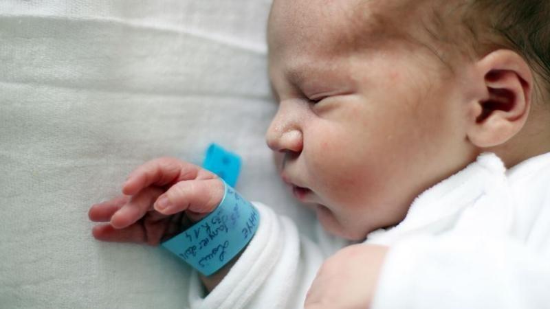 Bebê na maternidade com pulseira com seu nome e informações pessoais