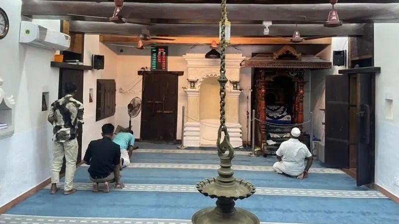চেরামান মসজিদের ভেতরে ঝুলন্ত প্রদীপ। মসজিদে চার জন নামাজ পড়ছেন