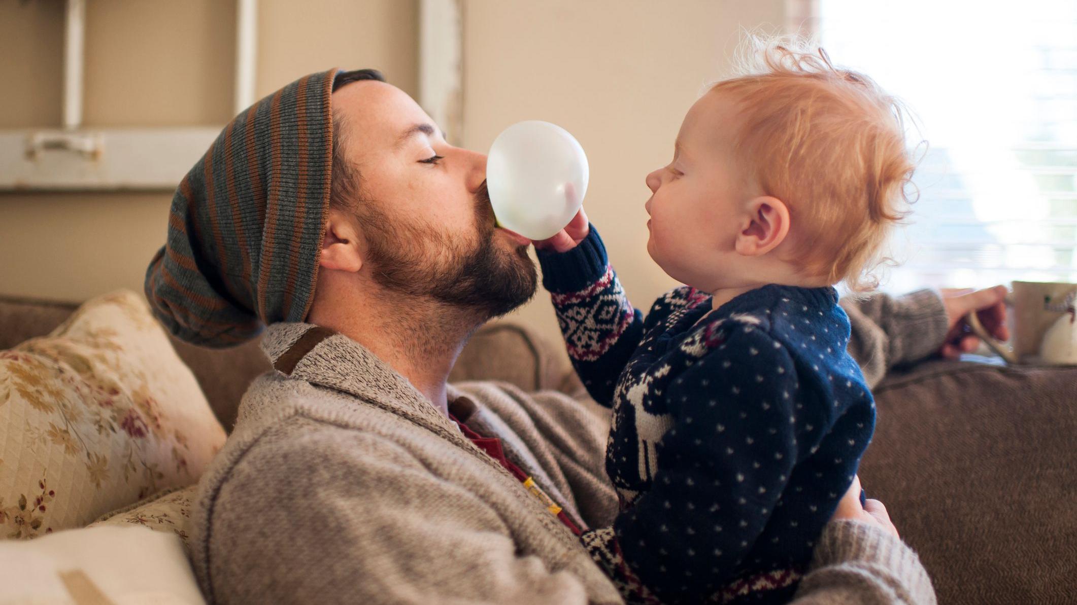 Un papa hace una pompa con un chicle y su bebe la explota con la mano