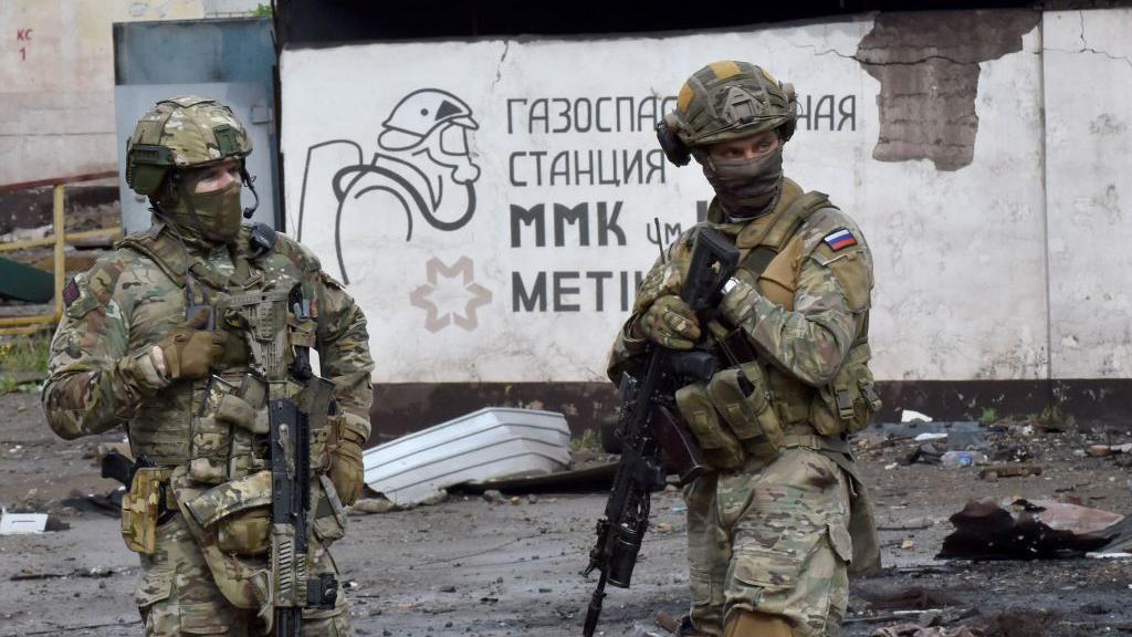   Soldados russos fazem guarda em frente à parte destruída da siderúrgica Ilyich, na cidade portuária ucraniana de Mariupol, em 18 de maio de 2022, enquanto a ofensiva militar russa continua na Ucrânia. 