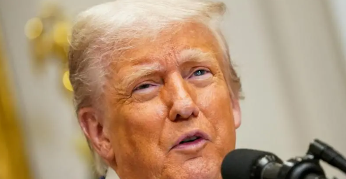 Foto mostra rosto de Donald Trump em frente a um microfone