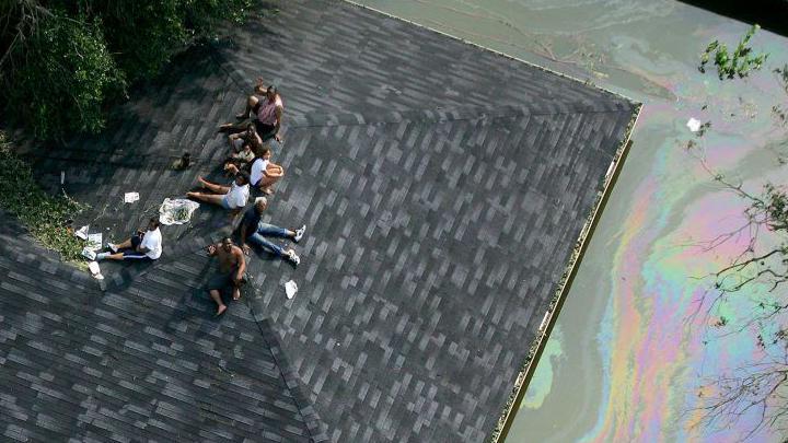 Un grupo de sobrevivientes de Katrina en el techo de una casa