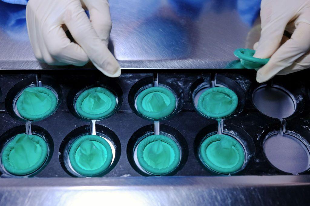 Um funcion&aacute;rio carrega preservativos enrolados em uma esteira na linha de produ&ccedil;&atilde;o de uma unidade da Karex na Mal&aacute;sia, em 03/06/2020