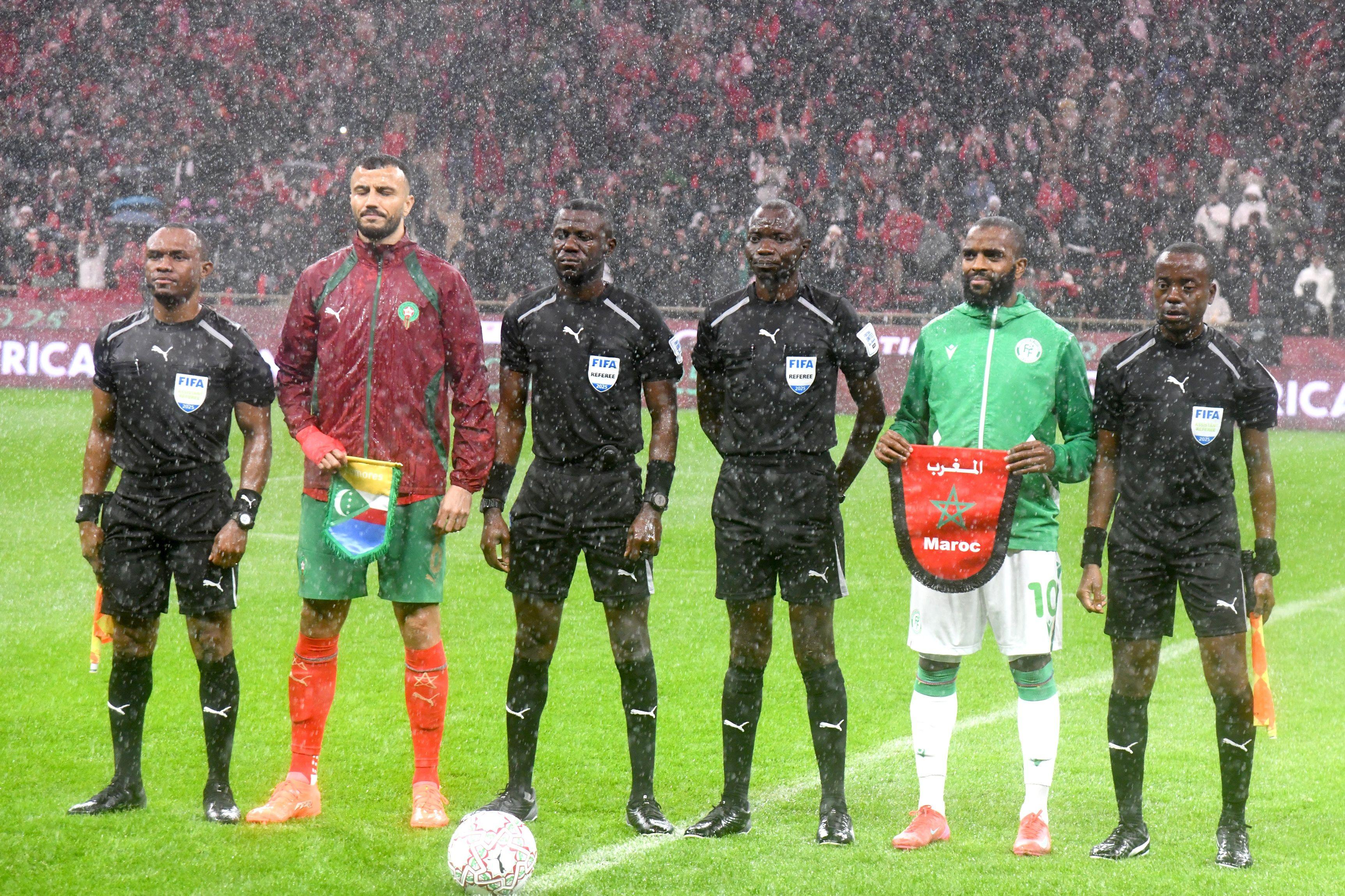 قائدا المنتخبين المغربي وجزر القمر يقفان مع حكام اللقاء قبل انطلاق مباراة الافتتاح في كأس أفريقيا لكرة القدم على ملعب الأمير مولاي عبد الله في الرباط