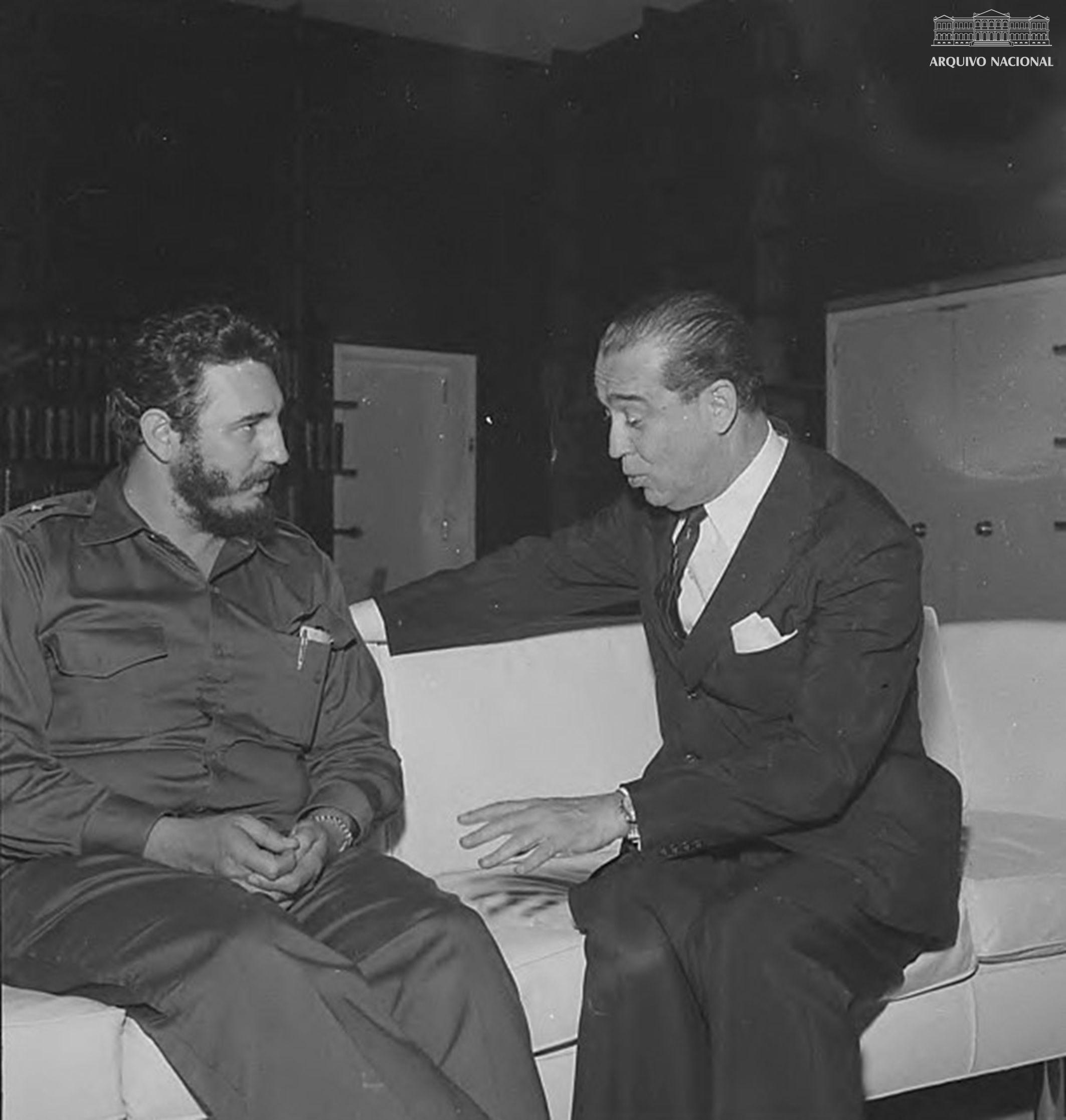 Fidel Castro e Kubitschek sentados em um sof&aacute; branco em uma foto em preto e branco. 