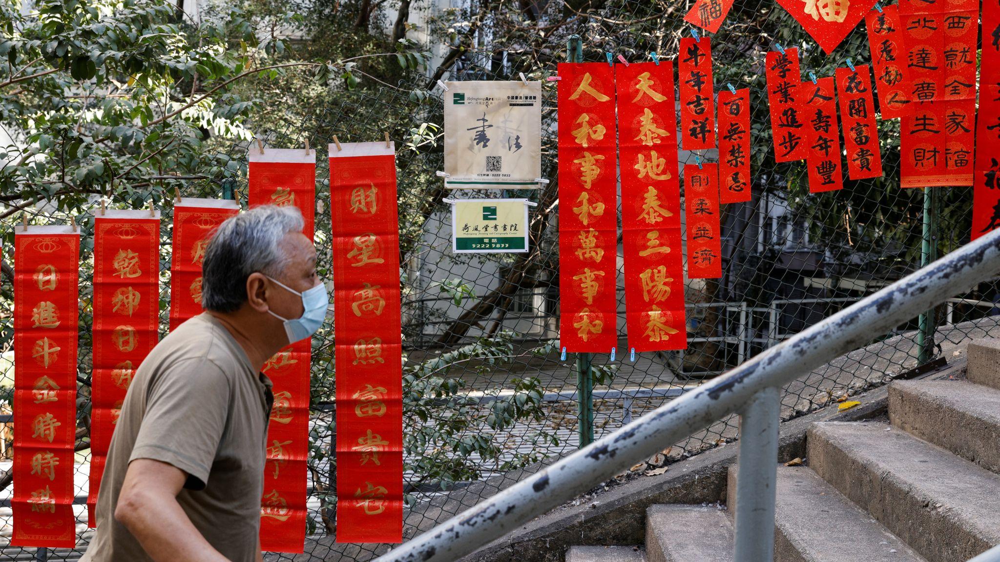 香港島某攀山樓梯街一位老人走過掛滿路旁以繁體字書寫的春聯（資料圖片）