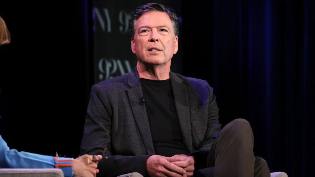 James Comey sentado, durante entrevista