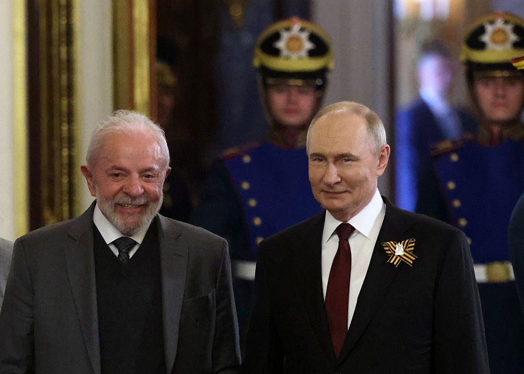 Lula e Putin sorrindo lado a lado, com escolta presidencial atrás