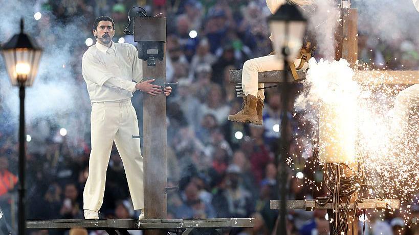 Bad Bunny canta subido a un poste de luz