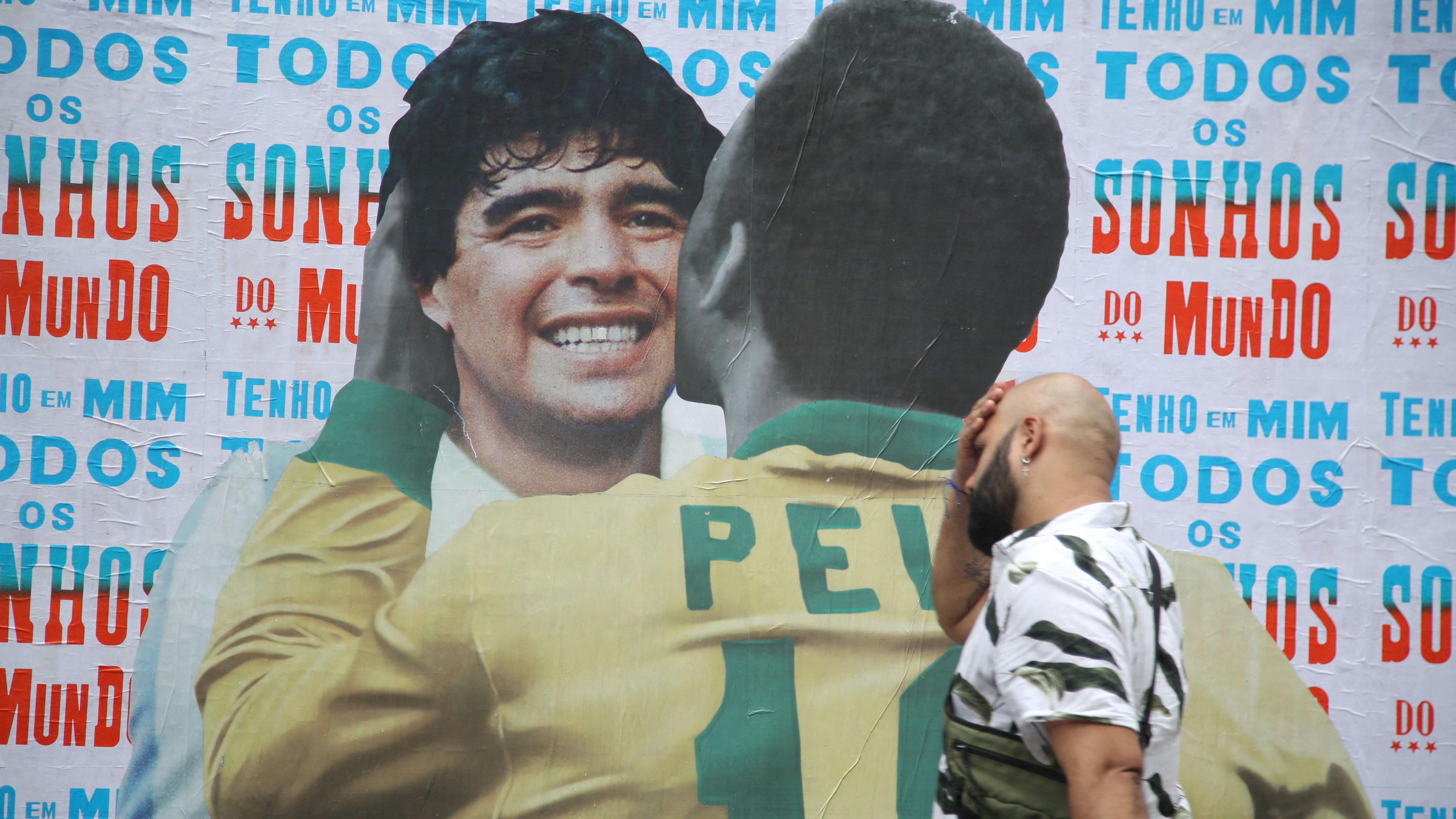 Pele, Maradona ili Mesi: Ko je zaista najbolji fudbaler svih vremena 1 maradona i pele, muškarac prolazi pored kolaža napravljenog od fotografija maradone i pelea