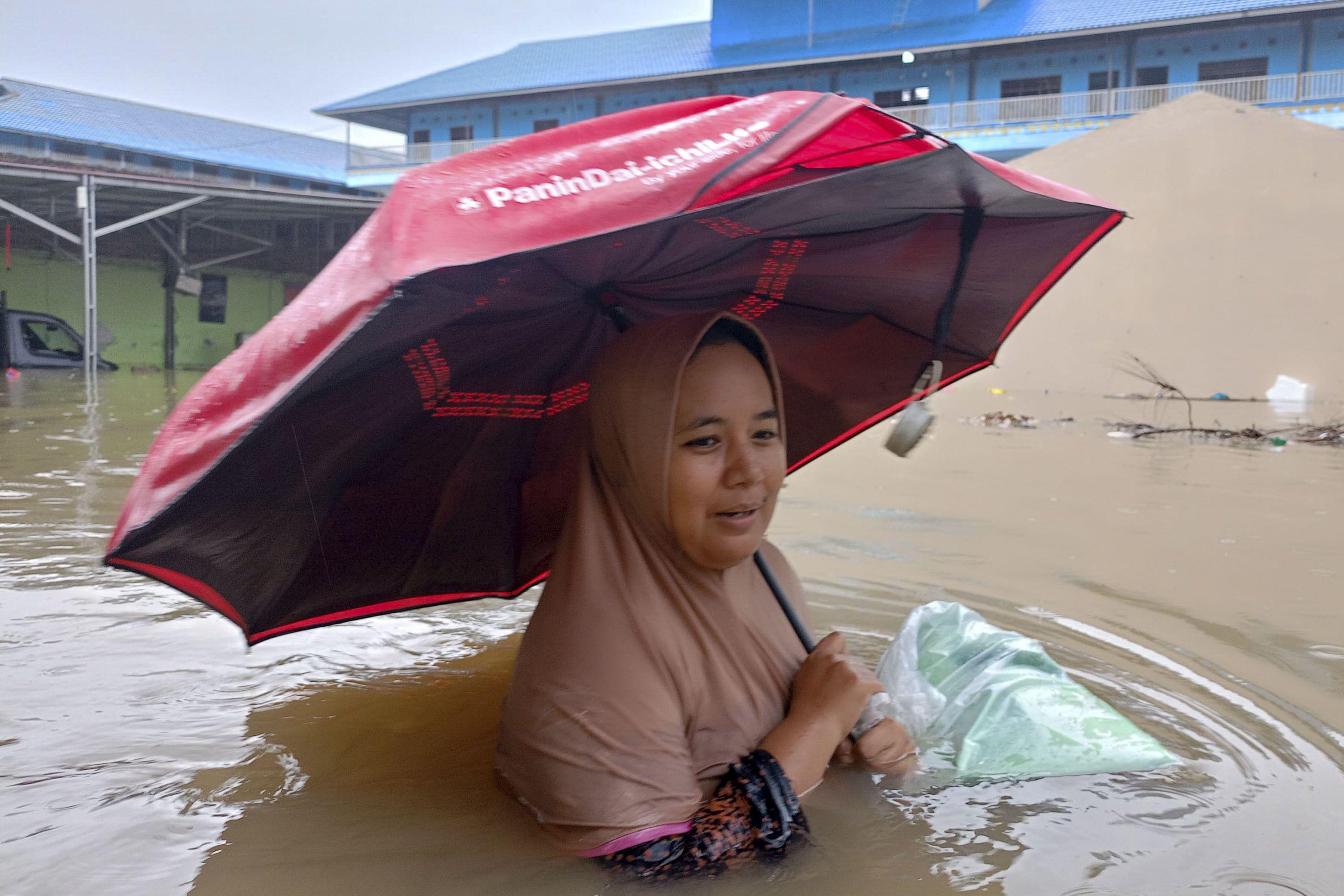 지난11월 27일 인도네시아 북수마트라 델리 세르당 지역 주민이 가슴까지 물이 찬 상태로 걷고 있다