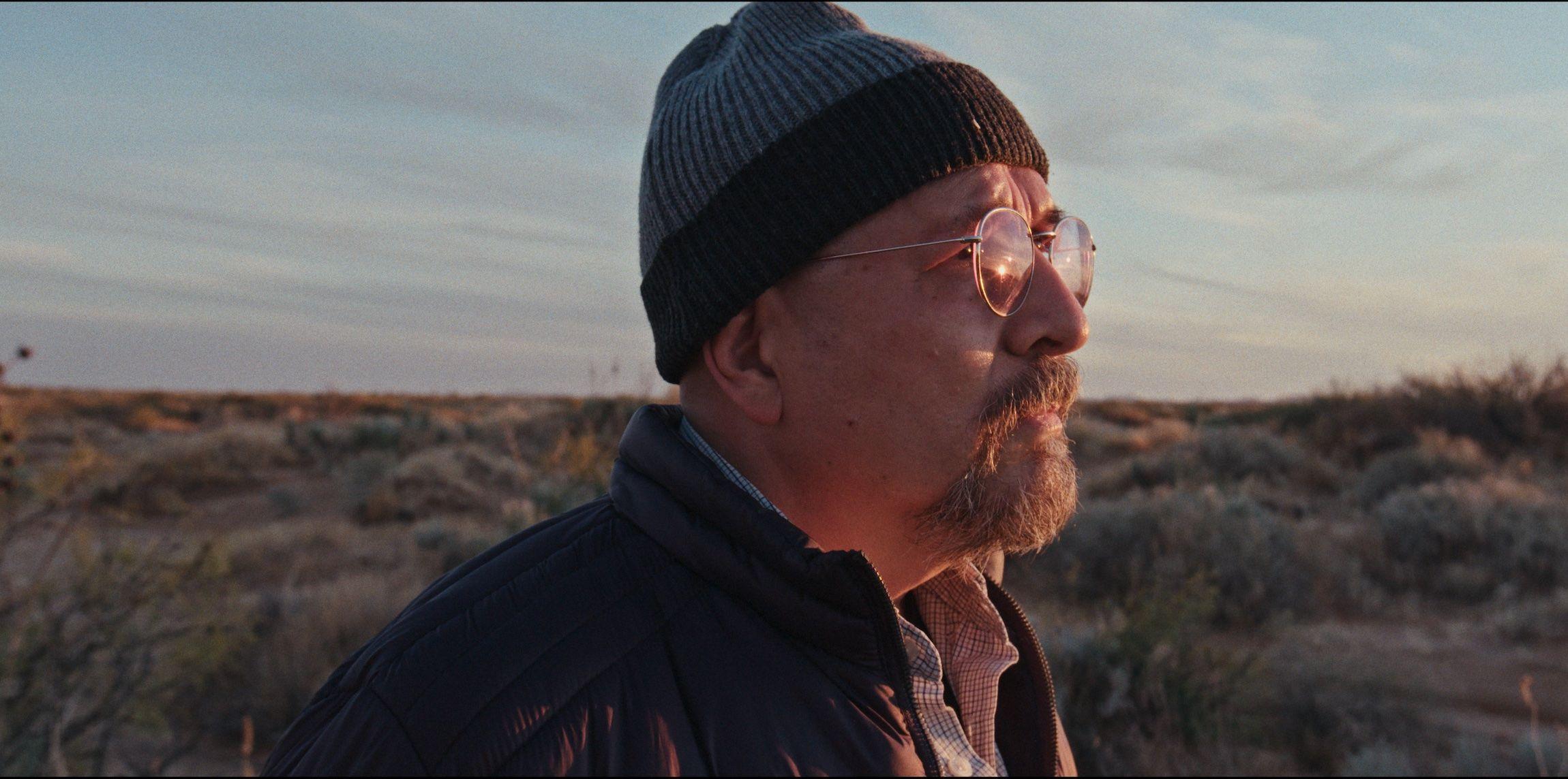 César Fierro mira hacia el horizonte en una de las tomas del documental "La libertad del Fierro". La luz del atardecer le ilumina el rostro.