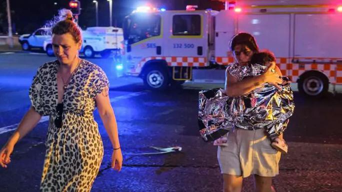 Napad na Jevreje u Sidneju: Najmanje 12 mrtvih; 'Terorizam', kaže premijer Albaneze 1 Majka nosi dete sa plaže Bondi u Sidneju