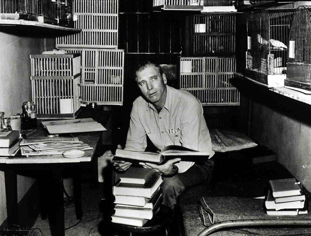 Burt Lancaster en la película "El hombre de Alcatraz" en una celda con jaulas de pájaros.