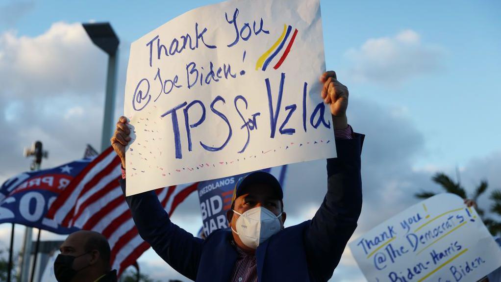 Eleazar Guevara, originario de Venezuela, y otros se reúnen frente al restaurante El Arepazo para mostrar su apoyo a una orden firmada por el presidente de Estados Unidos, Joe Biden, que otorga estatus de protección temporal a miles de venezolanos el 9 de marzo de 2021 en Doral, Florida. La administración Biden anunció que dará a unos 300,000 venezolanos que viven en Estados Unidos la oportunidad de permanecer y trabajar en el país durante 18 meses, una medida que los observadores consideran como un aumento de la presión sobre el presidente venezolano Nicolás Maduro. (Foto de Joe Raedle/Getty Images)