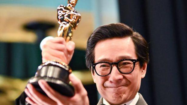 Ke Huy Quan aparece segurando uma estatueta do Oscar