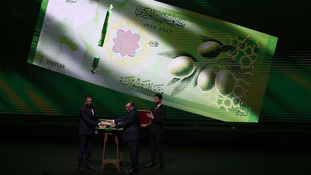 الرئيس السوري أحمد الشرع وحاكم مصرف سوريا المركزي عبد القادر حصرية حفل إطلاق العملة الجديدة في قصر المؤتمرات دمشق الاثنين 29-12-2025