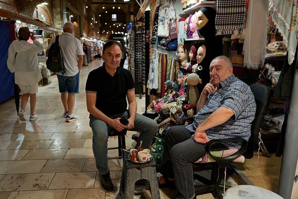 Dos hombres sentados en un bazar de Sarajevo.