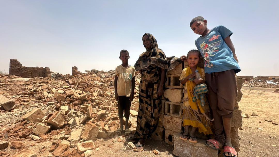 سيدة مع اطفالها الثلاثة وسط ركام منزلهم المهدم تماماً