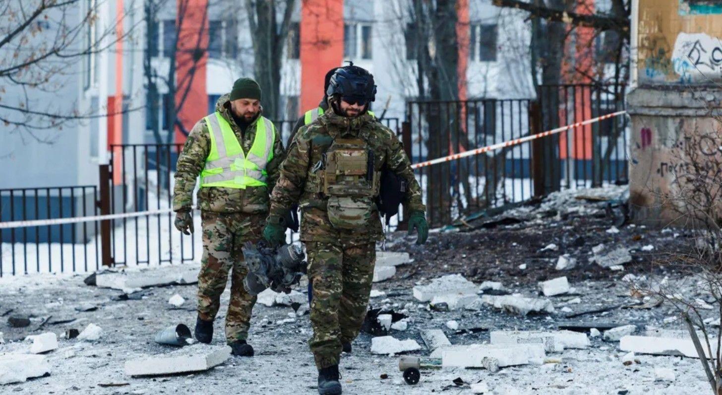 ضابط شرطة يحمل جزءاً من طائرة روسية مسيّرة في موقع مبنى سكني بالعاصمة كييف، في 3 فبراير/شباط 2026