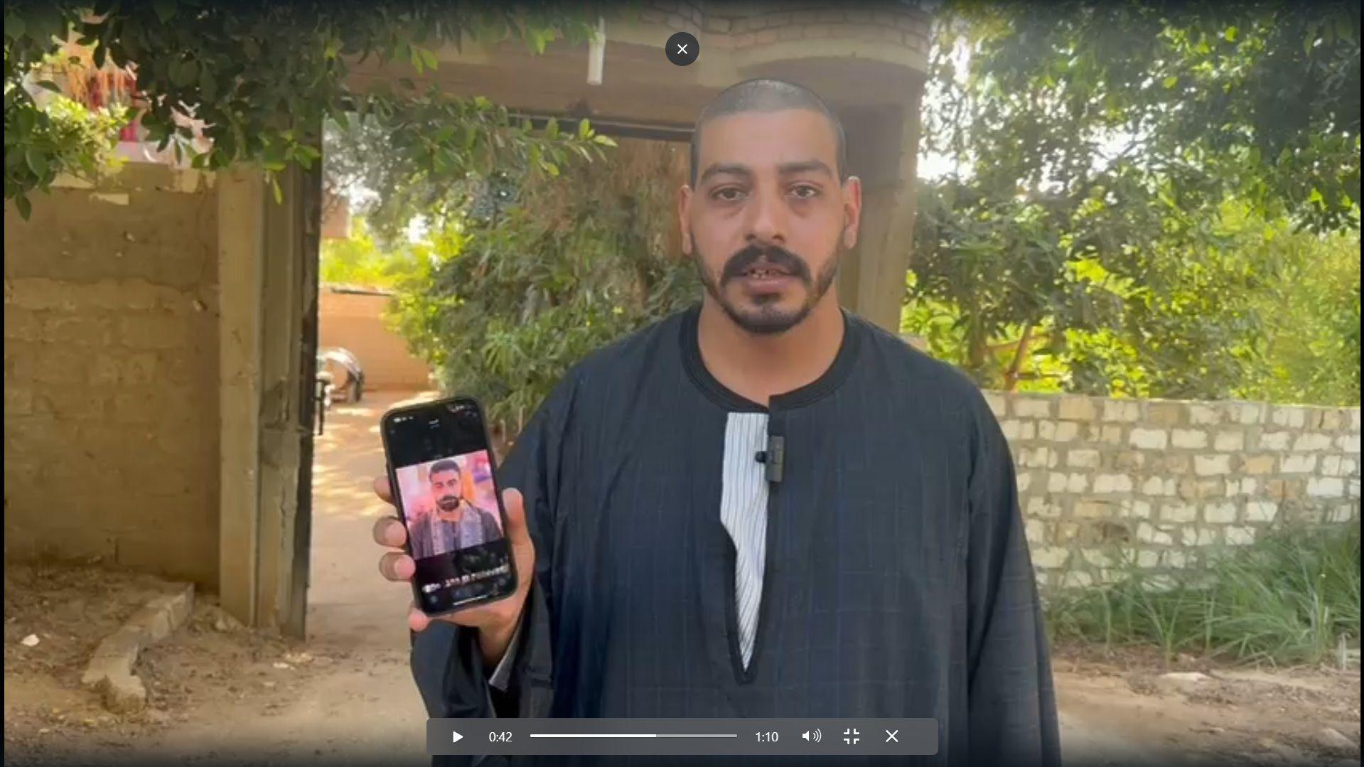محيي مع صورة أخيه المفقود في قارب طبرق الغارق